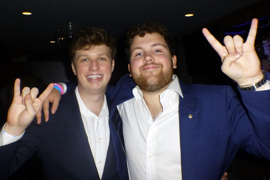 TKE brothers dressed in blue and black suits at a formal event