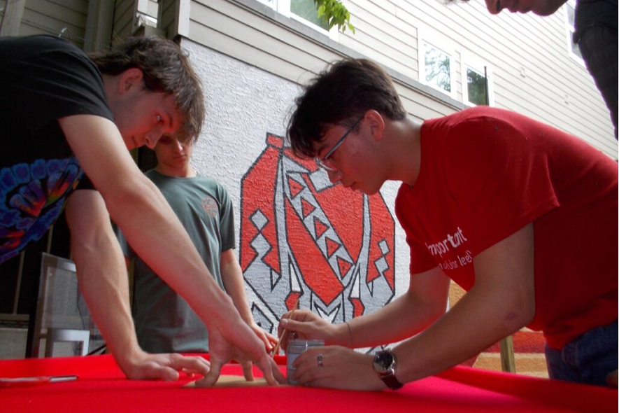 TKE brothers painting a table for a chapter tailgate tradition